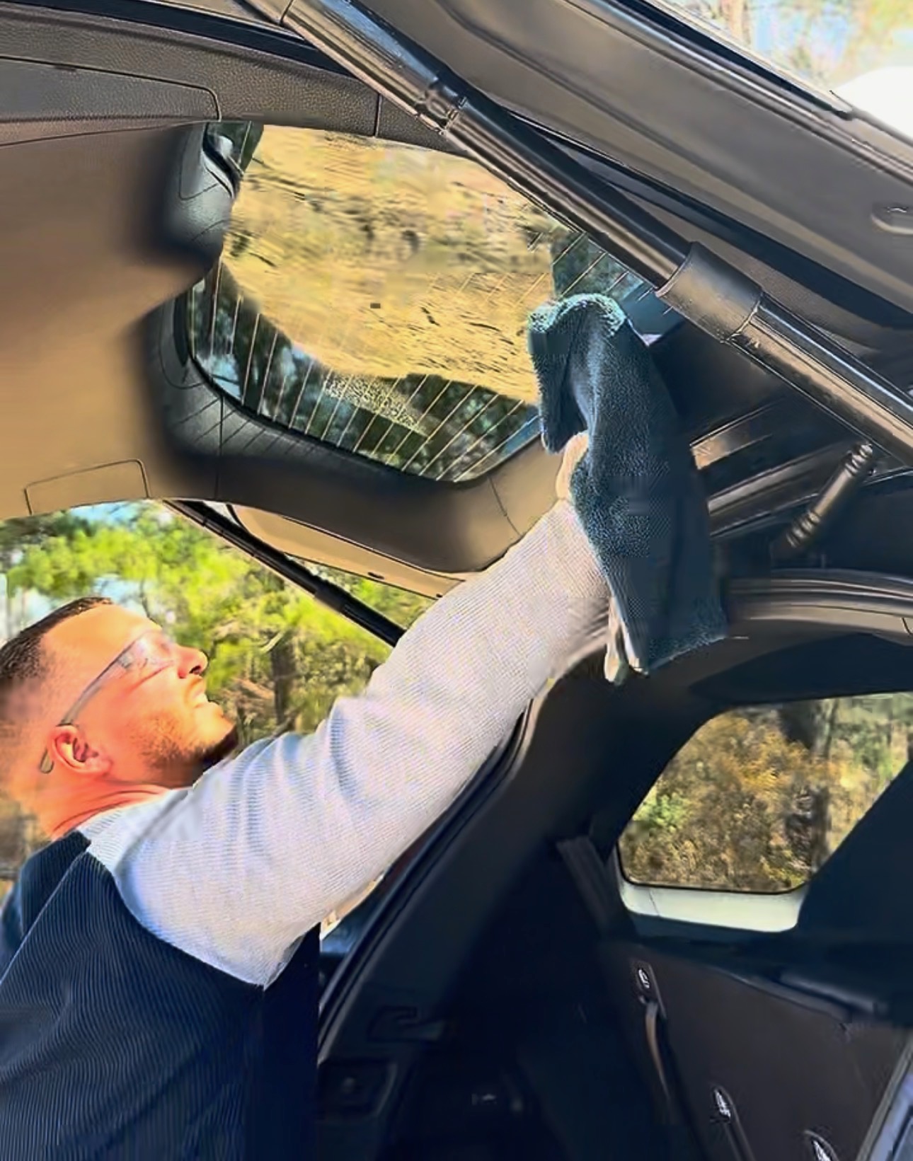 Interior detail — cleaning headliner and rear glass on SUV